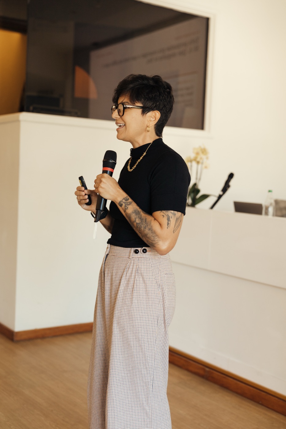 Nanny Faggiano falando ao microfone no palco do Origens