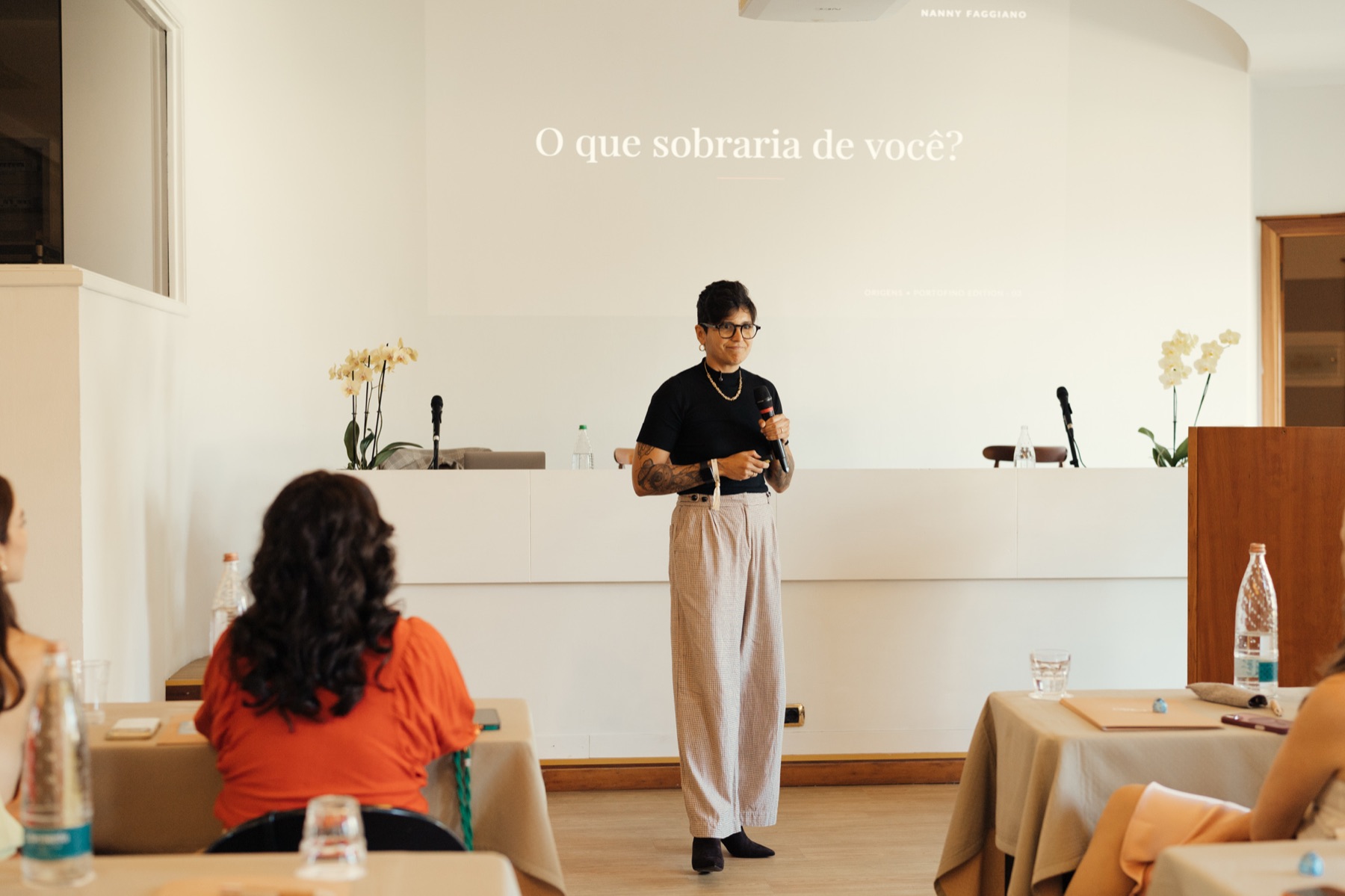 Nanny no palco diante da plateia, com a pergunta “O que sobraria de você?” projetada ao fundo